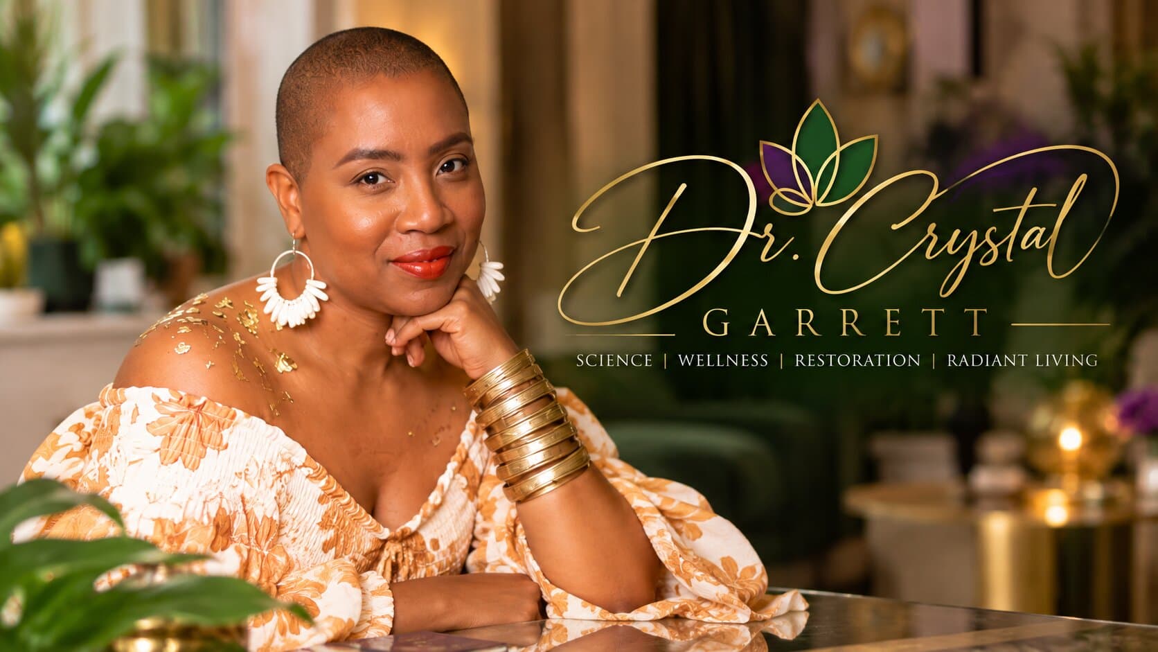 Dr. Crystal Garrett smiling, resting her chin on her hand, beside the gold Dr. Crystal Garrett logo with its green and purple leaves